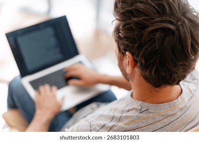 Focused man, programmer working on laptop computer indoors. checking mail. Copywriter typing on keyboard. Online technology concept