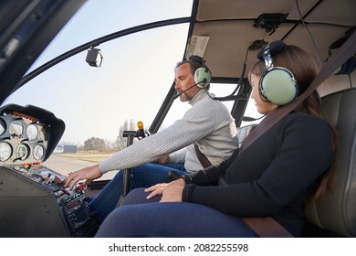 Focused Man In Safety Gear Flying A Helicopter With Kid