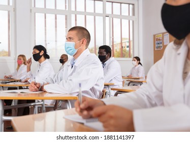 Focused Man Studying In Classroom With Colleagues Medicals In Protective Face Masks For Disease Prevention During Training Program For Health Workers