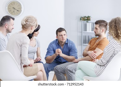 Focused Man Talking To People In White Room During AA Meeting
