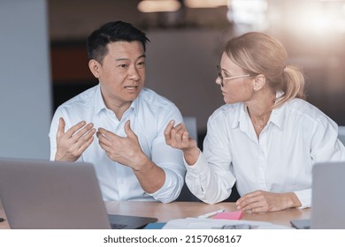 Focused Mature Female Employee Discussing Project, Showing Presentation To Skilled Team Leader. 