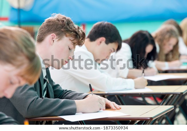 Focused middle school students taking examination
at desks