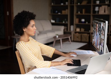 Focused millennial african american woman working distantly on computer, holding video conference negotiations remote meeting with skilled male team leader and diverse colleagues in modern office. - Shutterstock ID 2051406992