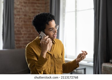 Focused Millennial African Business Woman In Glasses Speaking On Cell, Making Telephone Call From Home, Giving Consultation To Client. Customer Talking To Support Service, Contact Center