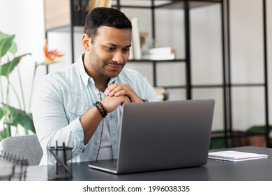 Focused Millennial Indian Man Looking At Laptop Screen Sitting At Home Office, Sitting At Desk With Computer Enjoying Remote Job, Online Studying At Home Concept Distance Education