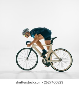 Hombre enfocado y motivado, ciclista profesional que monta en bicicleta, compitiendo por la victoria aislado en el fondo blanco. Concepto de deporte, competición, estilo de vida activo, resistencia