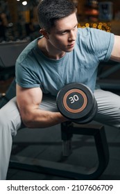 Focused Muscular Young Man Doing Bicep Curl