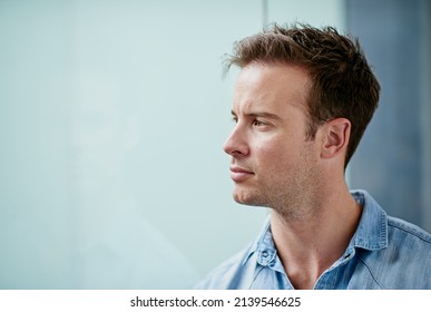 Focused On The Future. Shot Of A Handsome Young Man Looking Thoughtful In A Casual Work Environment.