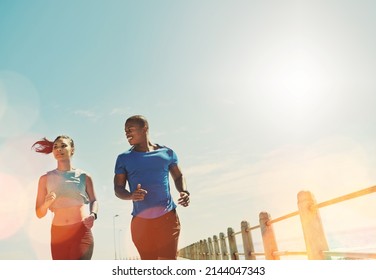 Focused On Getting Fit Together. Shot Of A Young Sporty Couple Out For A Run Together.