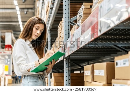 Focused on her task, a young woman holding clipboard meticulously updates inventory records while surrounded by shelves filled with various products in a vibrant warehouse setting