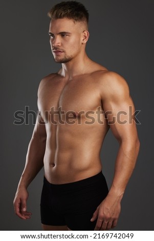 Focused on his fitness goals. Cropped shot of a handsome and athletic young man posing shirtless in studio against a dark background.