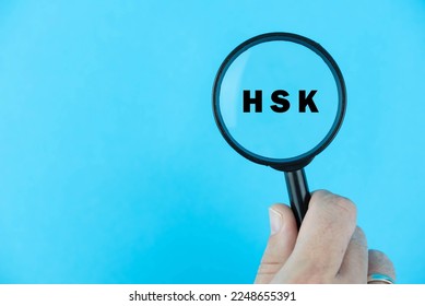 Focused on HSK exam. Word HSK (Hanyu Shuiping Kaoshi) under magnifying glass. Chinese Language Proficiency Test. Test Preparation. E-learning.