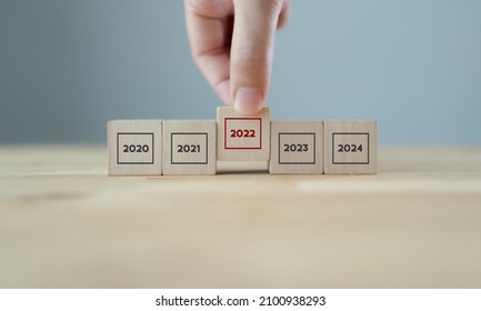 Focused On Year 2022. Business Planning And Strategy In New Year. Performance And Highlight Concept. Hand Hold Wooden Cubes With Text 2022 On Grey Background. Start Of Year Concept.  2022 Banner.