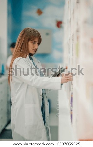 Focused pharmacist using digital tablet to check medications in drugstore, showcasing dedication to healthcare. Organized shelves highlight attention to detail in pharmaceutical industry