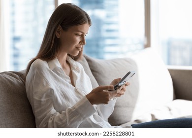 Focused positive young adult digital addict girl using pair of mobile phones for data analysis, file transfer, enjoying wireless connection technology, communication, online service, application - Shutterstock ID 2258228801