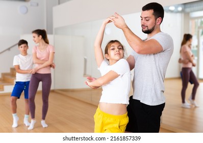 Focused Pre-teen Girl Exercising Dance Moves With Dad At Family Dance Class, Family Practicing Dance In Pair