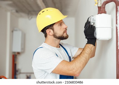 Focused Professional Heating Fitter Checking Gas Consumption At Gas Pipe And Meter Counter