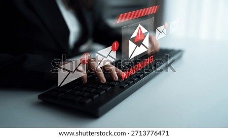 A focused professional interacts with a keyboard while processing cybersecurity warnings. This image illustrates digital safety and awareness in a modern workspace setting. Gantry