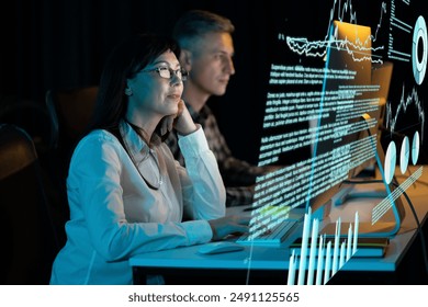 Focused Professionals Analyzing Data On Screens In Dark Office, Reflecting Modern Technology, Teamwork, And Innovation