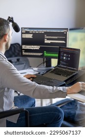 Focused Programmer Working on Dual Monitors with Software Applications