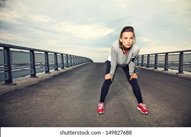 Focused runner outdoors resting on the bridge - Powered by Shutterstock