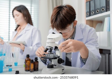 Focused Scientist Using Microscope for Chemical Observations