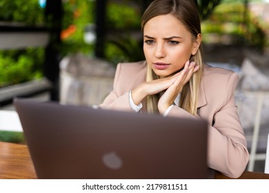 Focused Smart Cafe Owner Sitting At The Table Working At Her Laptop.