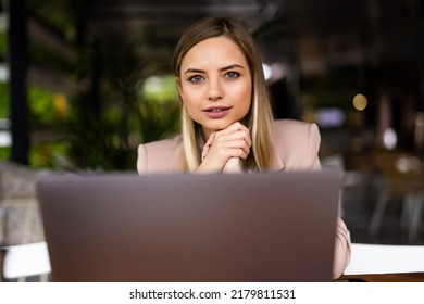 Focused Smart Cafe Owner Sitting At The Table Working At Her Laptop.