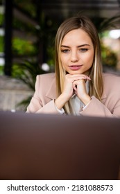 Focused Smart Cafe Owner Sitting At The Table Working At Her Laptop.