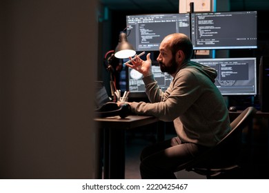 Focused software engineer thinking about source code to develop database online cloud, brainstorming ideas after hours. Being pensive and working on system interface, app programming.