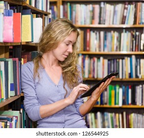 focused student using a tablet computer in a library