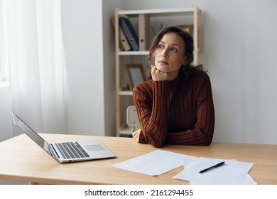 Focused Thoughtful Unhappy Sad Curly Beautiful Woman Lost In Heavy Thoughts Looks Aside Think About Difficult Life Decision Sitting At Home Office. People Problems Concept