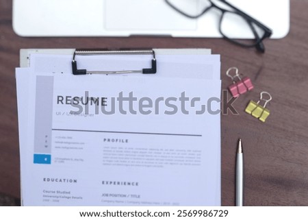 A focused view of job application documents and resume papers on a clipboard, emphasizing job search and application.