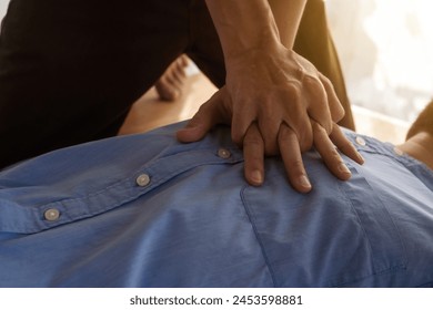 A focused view of a man demonstrating chest compressions on a CPR training class, illustrating hands-on learning in a classroom setting to master life-saving techniques for emergency response. - Powered by Shutterstock