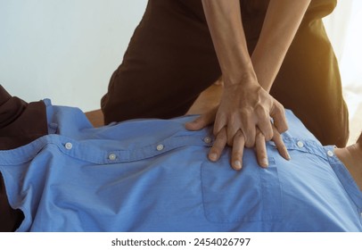 A focused view of a man demonstrating chest compressions on a CPR training class, illustrating hands-on learning in a classroom setting to master life-saving techniques for emergency response. - Powered by Shutterstock