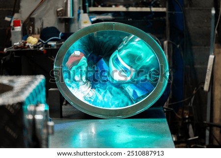 Focused welder creating strong welds on a circular metal piece, sparks flying around in the workshop.