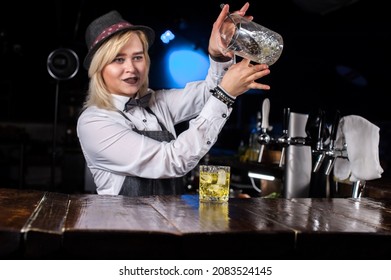 Focused Woman Mixologist Places The Finishing Touches On A Drink In Cocktail Bars