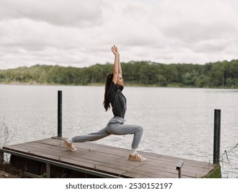 Focused woman practicing yoga on dock by serene lake, demonstrating warrior pose amidst nature Health and wellness concept with tranquility and strength - Powered by Shutterstock