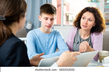Focused woman and son sitting at home and listening social worker