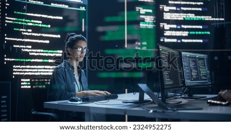 Focused Woman Working as a Developer, Surrounded by Big Screens Displaying Lines of Code in a Monitoring Room. Female Programmer Using Desktop Computer, Analysing Data, Creating AI Software