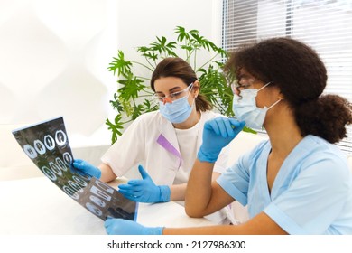 Focused Worried Multiethnic Healthcare Workers Analyzing CT Lung Screening While Working In Medical Clinic Or Hospital, Medical Team Looking At X-ray Scan Discussing Diagnosis Or Treatment Options