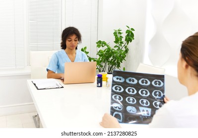 Focused Worried Multiethnic Healthcare Workers Analyzing CT Lung Screening While Working In Medical Clinic Or Hospital, Medical Team Looking At X-ray Scan Discussing Diagnosis Or Treatment Options