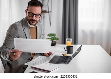 Focused young adult businessman, making sure his company is earning enough money. - Shutterstock ID 2203330431