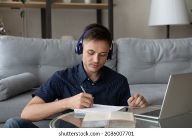 Focused Young Adult Student Guy Wearing Wireless Earphones, Making Notes, Writing In Notebook, Listening To Online Learning Lecture, Music For Study, Deep Focus, Concentration, Working At Laptop