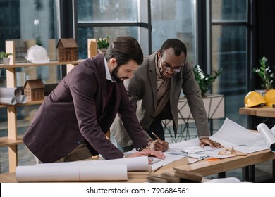 focused young architects drawing architectural plans together - Powered by Shutterstock