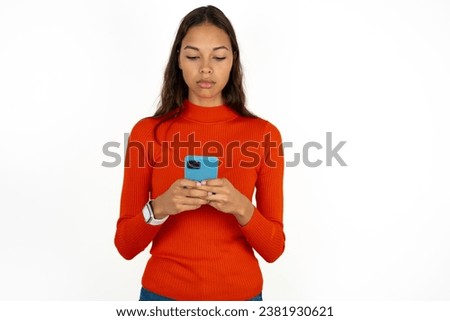 Focused Young beautiful woman wearing red sweater use smartphone reading social media news, or important e-mail