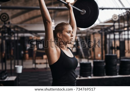 Similar – young adult trained woman concentrate at her excercise in gym