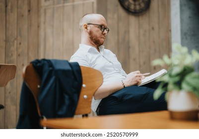 Focused young business entrepreneur in an outdoor setting, taking notes in a notebook. The image captures a professional, thoughtful moment. - Powered by Shutterstock