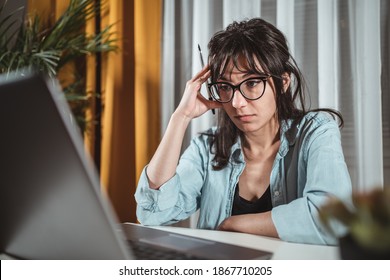 Focused young businesswoman sitting at desk looking at laptop screen browsing surfing Internet at home, smiling millennial female employee work on modern computer in living room, technology concept - Shutterstock ID 1867710205