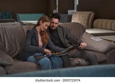 Focused Young Couple Looking At Fabric Swatches